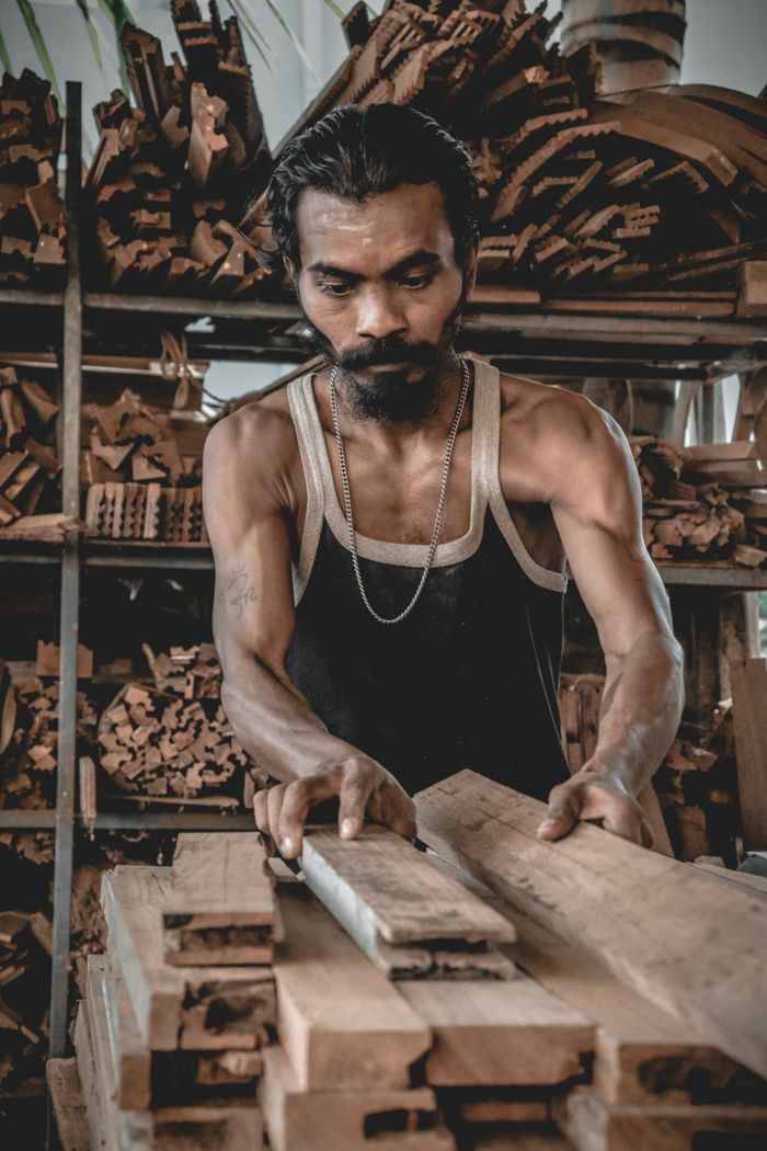 The Art of Drawing Readers In: Your attractive post title goes here A focused artisan working on a woodworking project in an indoor workshop with wooden boards.